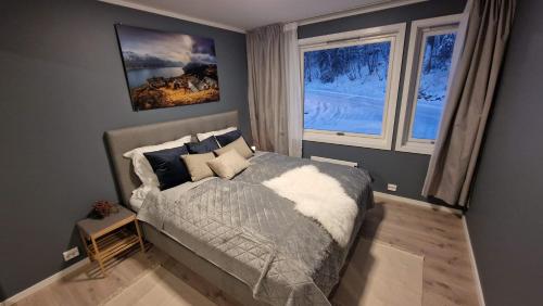 a bedroom with a bed and two windows at Haugetuft Apartments in Åmot