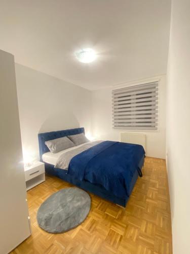 a bedroom with a bed with a blue blanket at Apartman Nova Pale in Pale