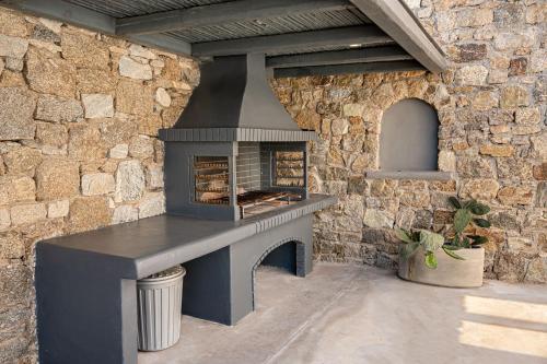 a stone wall with an outdoor oven in a patio at Tohu Villas Mykonos in Ornos