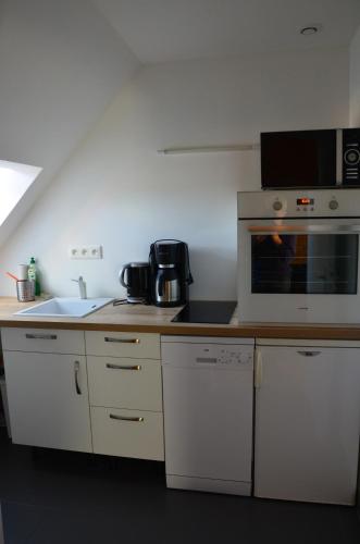 a kitchen with a sink and a microwave at Le Tertre de la Nouette in La Bosse-de-Bretagne