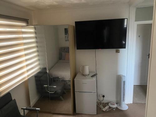 uma sala de estar com uma televisão na parede em Alder en-suite self caring private shower 2 em Southampton