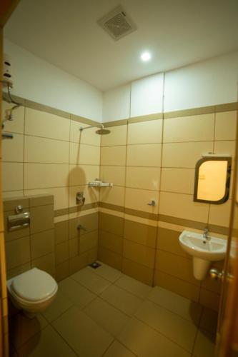a bathroom with a toilet and a sink at OPM INN in Payyannūr