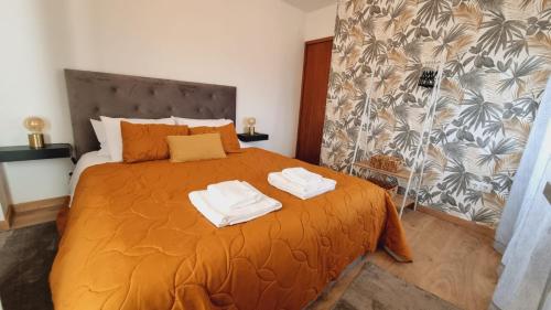 a bedroom with a bed with two towels on it at CASAS DO CÔA - Casa Santa Luzia in Vila Nova de Foz Coa