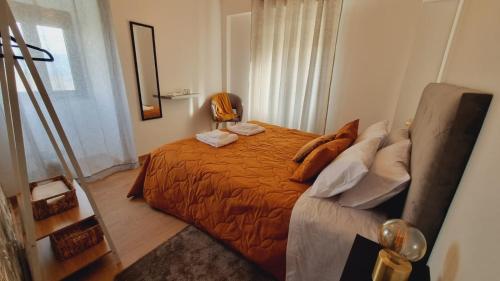 a bedroom with a bed with an orange blanket at CASAS DO CÔA - Casa Santa Luzia in Vila Nova de Foz Coa