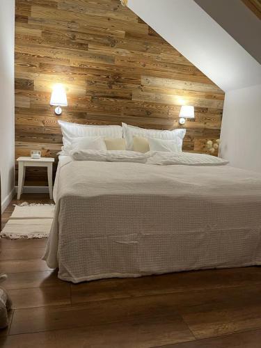 sypialnia z dużym łóżkiem i drewnianą ścianą w obiekcie Apartamenty na Poddaszu- Tatarska 4 w mieście Przemyśl
