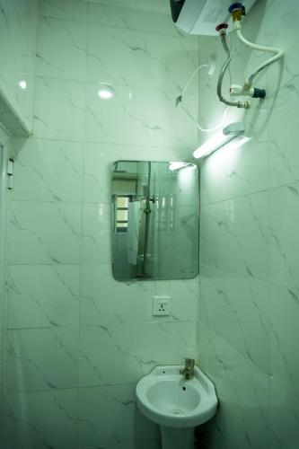 a white bathroom with a sink and a mirror at Admirable 2-bed-Apt With 24hrs Power & Starlink SuperFast Speed WiFi in Amuwo