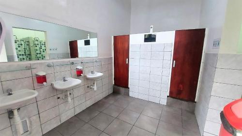 a bathroom with two sinks and two mirrors at 1900 Hostel in Lima