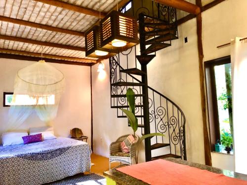 a bedroom with a spiral staircase and a bed at Gaia Eco Glamping - Instituto Almas Livres in Arraial d'Ajuda