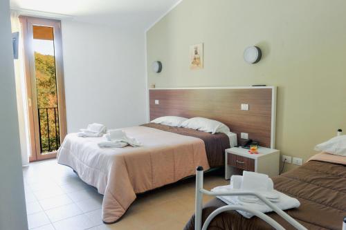 a hotel room with two beds and a window at Chalet Madonna di Viggiano in Viggiano