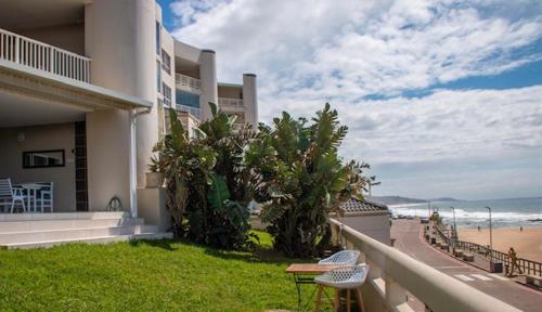 a balcony of a house with a view of the beach at GARDEN ON THE BEACH in Umdloti