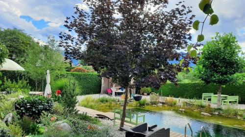 a garden with a tree and a pond at Garden Paradise Bled Apartments - garden, pond and castle view in Bled