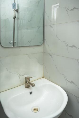 a white sink in a bathroom with a mirror at Live By The Water 2-Bed-Apt With Starlink SuperFast Speed Wi-Fi And Secured in Amuwo
