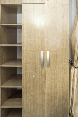 a wooden cabinet with silver handles in a room at Live By The Water 2-Bed-Apt With Starlink SuperFast Speed Wi-Fi And Secured in Amuwo