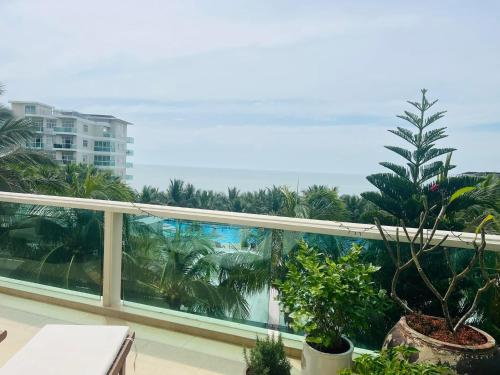 a balcony with a view of the ocean and palm trees at La Vista Mui Ne in Ấp Phú Tịnh (2)