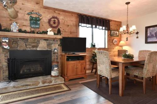 a living room with a fireplace and a table with chairs at Seven Springs 3 Bedrooms Premium Condo, Ski In Ski Out condo in Champion