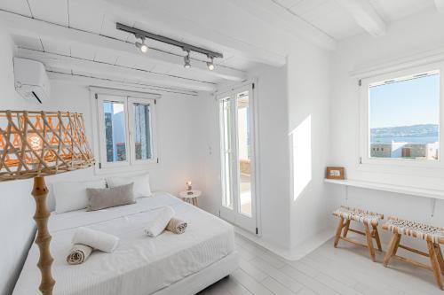 a white room with a bed and some windows at Tohu Villas Mykonos in Ornos