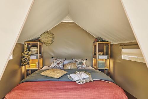 a bedroom with a bed in a tent at Camping Du Paquier Fané in Chagny