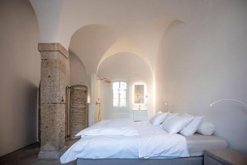 Habay-la-Neuve的住宿－Château du Pont d'Oye，白色卧室配有一张带白色枕头的大床