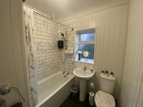 a bathroom with a sink and a toilet and a bath tub at Home Away From Home Near Derby City Centre - Sleep upto 7 in Derby