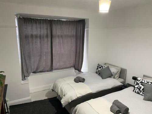a bedroom with two beds and a window at Home Away From Home Near Derby City Centre - Sleep upto 7 in Derby