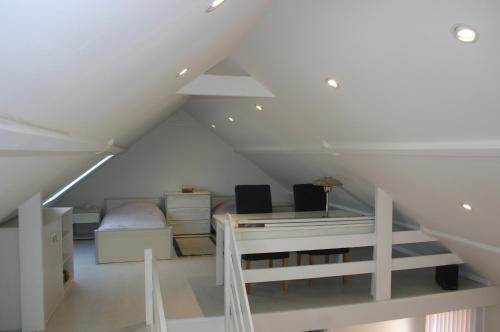 a attic room with a desk and a bed at "Zee en rust" in De Haan