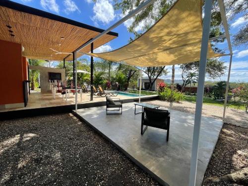 un patio al aire libre con mesa y sillas en Pyramid Tamarindo en Tamarindo