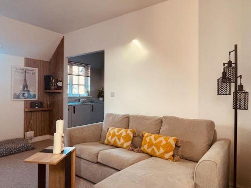 a living room with a couch and a table at Stylish, Comfortable Coach House in Falmouth
