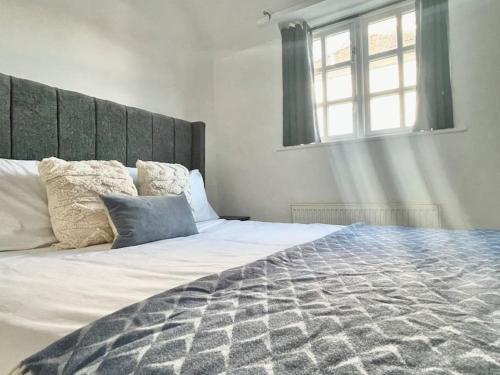 a bedroom with a large bed and a window at Stylish, Comfortable Coach House in Falmouth
