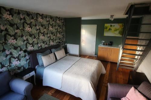 een slaapkamer met een bed en een bloemrijke muur bij B&B It Noflik Stee in Zweins