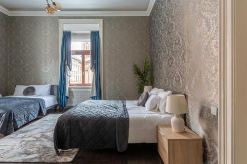 1 Schlafzimmer mit 2 Betten und einem Fenster in der Unterkunft Luxury Apartment With Balcony next to the New York Café in Budapest