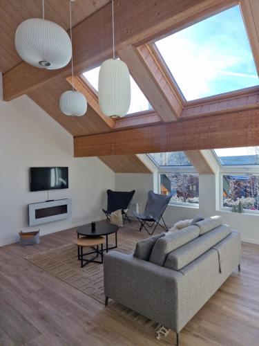 ein Wohnzimmer mit einem Sofa und einem Tisch in der Unterkunft Duplex type chalet dans le Jura in Morbier