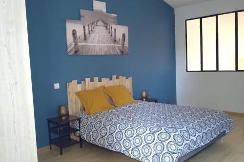 une chambre avec un lit avec un mur bleu dans l'établissement Location 3* Curistes et Vacanciers, à Jonzac