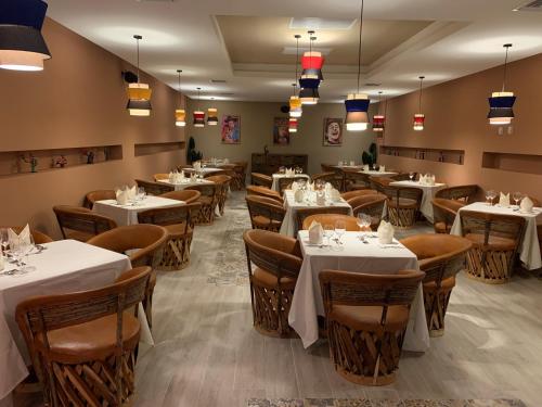 a restaurant with tables and chairs with white tablecloths at Viva Fortuna Beach by Wyndham, A Trademark All Inclusive in Freeport