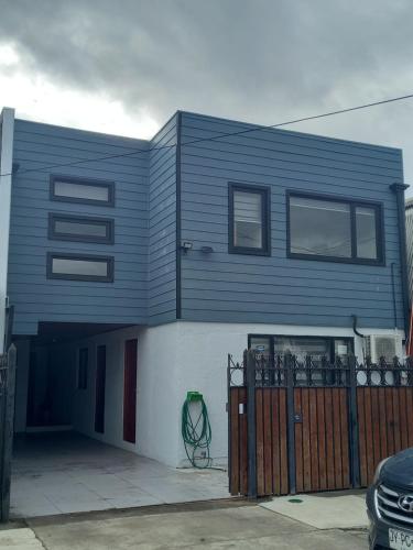 a blue house with a fence in front of it at Cabañas y Departamentos Las Palmas, Temuco Depto 1 in Temuco