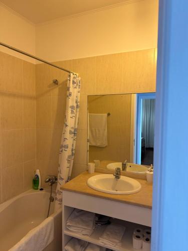 a bathroom with a sink and a tub and a mirror at Apartamento Freitas in Caniçal