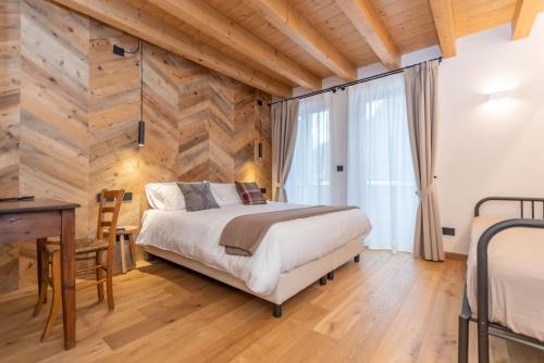 a bedroom with a bed and a wooden wall at B&B El Lares - B&B L'Avez in Canale dʼAgordo