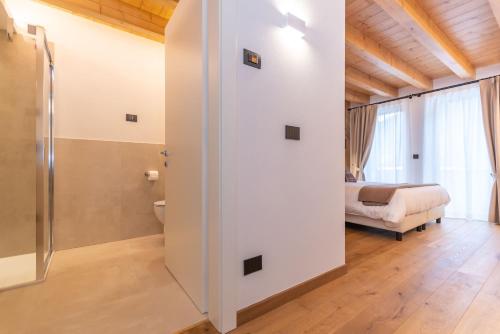 a bathroom with a shower and a bed in a room at B&B El Lares - B&B L'Avez in Canale dʼAgordo
