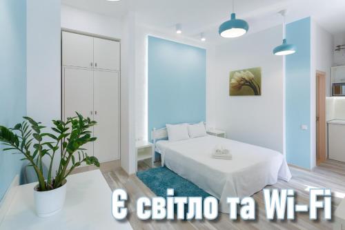 a bedroom with a white bed and a potted plant at Basseynaya Apart Hotel in Kyiv