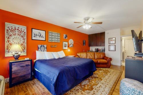 a bedroom with orange walls and a bed and a couch at Bella Paradiso 05 in Eureka Springs