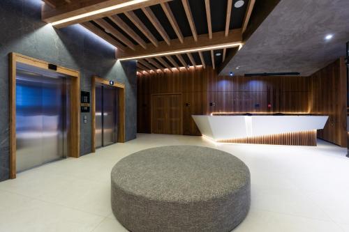 a lobby with a large ottoman in the middle of a room at Woodside Residences & SPA in Kopaonik