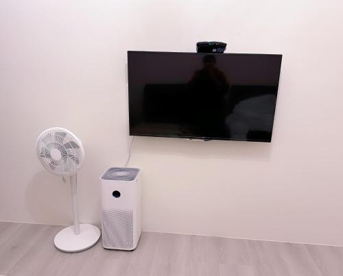 a television and a fan in a room at Happy Fat B&B 寵物友善 in Taitung City