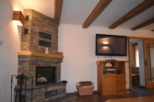 a living room with a fireplace and a flat screen tv at Chata Svojáč in Svojanov