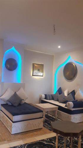 馬拉喀什的住宿－marrakech palmeraie village Etablissement jasmin，一间带两张床和一张沙发的客厅