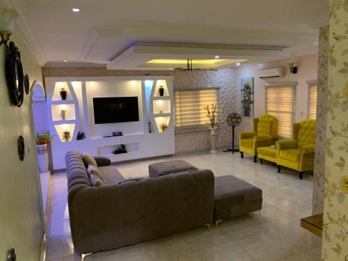 Agege的住宿－Charming Vacation 3BDR Duplex - Free Wi-Fi, Washing Machine, Mins to Airport，客厅配有沙发和2把黄色椅子