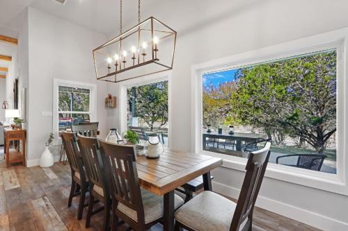 a dining room with a table and chairs and a window at Barndo on the Blanco in Wimberley
