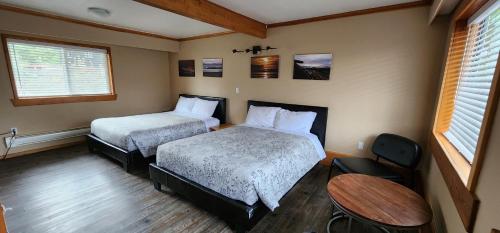 a hotel room with two beds and a table at Meares Vista Inn in Tofino