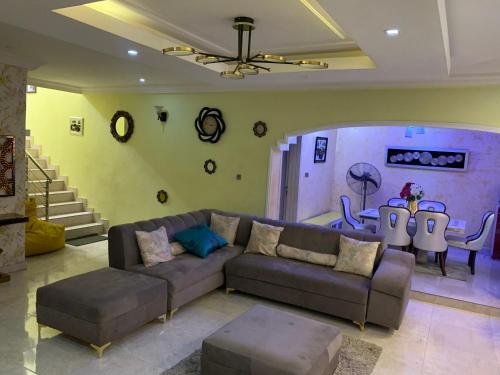 sala de estar con sofá y mesa en Charming Vacation 3BDR Duplex - Free Wi-Fi, Washing Machine, Mins to Airport, en Agege