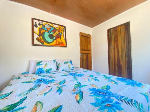 a bedroom with a bed with a blue comforter at Verano House BF in Baía Formosa