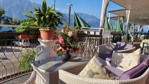 a wicker chair and a vase with flowers on a table at Hotel Merano in Brenzone sul Garda