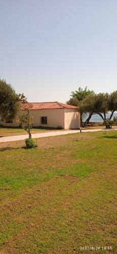 a building in a field with trees in the background at lemonishouse by the sea 2 in Nea Skioni